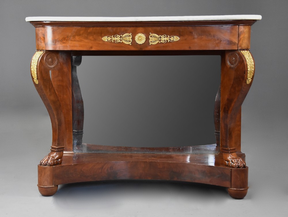 An early nineteenth-century French Charles X mahogany console table with a white marble top, curved front legs ending in paw feet, gilt-bronze mounts, and a mirrored back above a concave base. View V