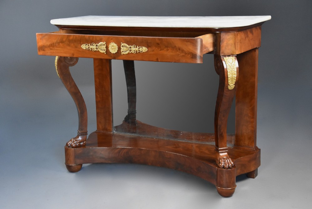 An early nineteenth-century French Charles X mahogany console table with a white marble top, curved front legs ending in paw feet, gilt-bronze mounts, and a mirrored back above a concave base. View IX