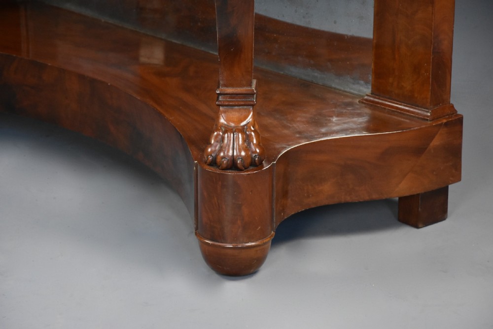 An early nineteenth-century French Charles X mahogany console table with a white marble top, curved front legs ending in paw feet, gilt-bronze mounts, and a mirrored back above a concave base. View XIII