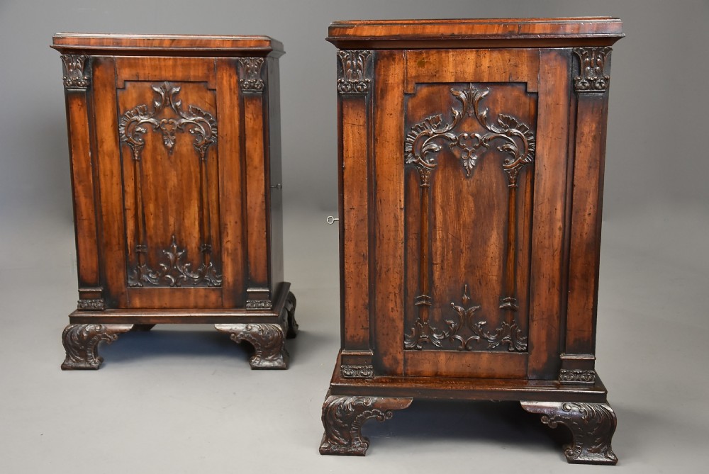 A pair of mid-18th-century mahogany Chippendale pedestal cabinets featuring relief-carved Rococo door panels, corner pilasters, and carved bracket feet.