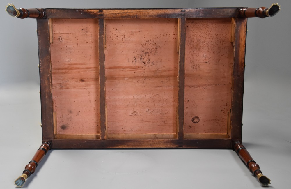 A Regency mahogany writing table featuring a dark leather insert, six drawers with brass knobs, and reeded turned legs with brass paw feet. View XIV