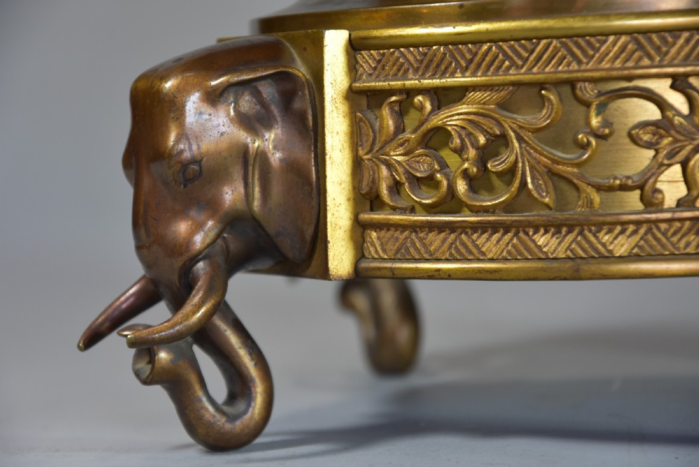 A late nineteenth-century three-piece French Japonisme bronze garniture set featuring a central incense burner flanked by two tall urns, decorated with gilt dragon reliefs and supported on elephant head feet. View VII