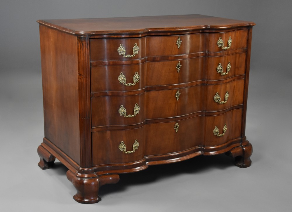 An 18th-century mahogany oxbow commode with four drawers, ornate brass bail handles, and prominent shaped feet. View III