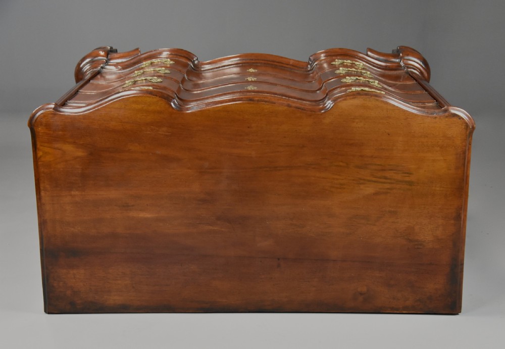 An 18th-century mahogany oxbow commode with four drawers, ornate brass bail handles, and prominent shaped feet. View XV