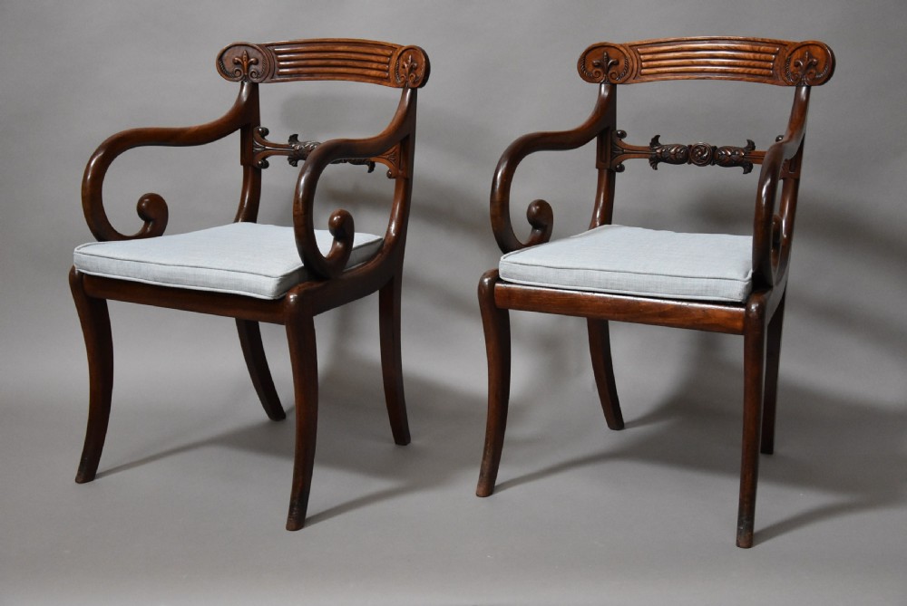 A set of eight antique Regency mahogany dining chairs featuring reeded top rails, carved mid-rails, scrolled armrests, and pale blue upholstered seats. View III