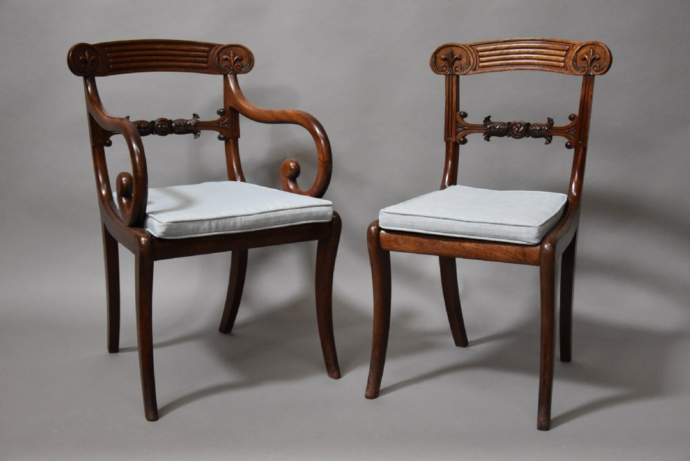 A set of eight antique Regency mahogany dining chairs featuring reeded top rails, carved mid-rails, scrolled armrests, and pale blue upholstered seats. View IV