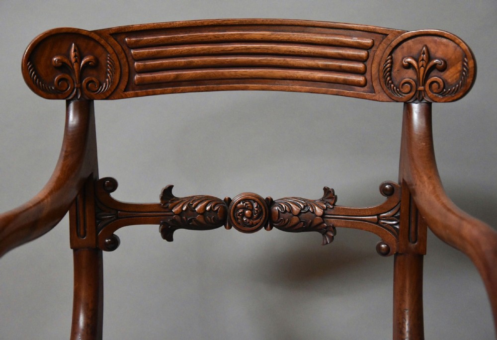 A set of eight antique Regency mahogany dining chairs featuring reeded top rails, carved mid-rails, scrolled armrests, and pale blue upholstered seats. View VIII