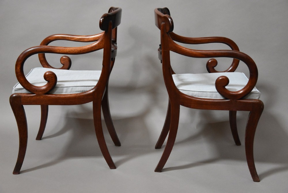 A set of eight antique Regency mahogany dining chairs featuring reeded top rails, carved mid-rails, scrolled armrests, and pale blue upholstered seats. View XI