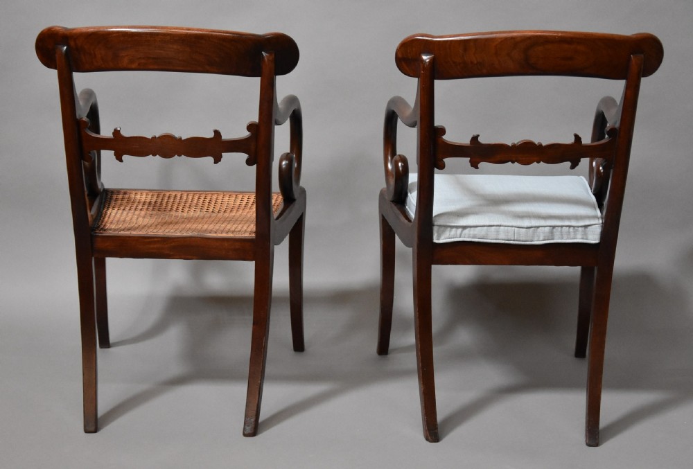 A set of eight antique Regency mahogany dining chairs featuring reeded top rails, carved mid-rails, scrolled armrests, and pale blue upholstered seats. View XII