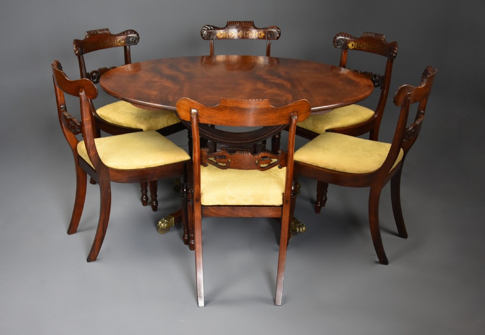 An early nineteenth-century circular mahogany centre table shown tilted upright on a central pedestal with four splayed legs terminating in brass paw castors. View VII