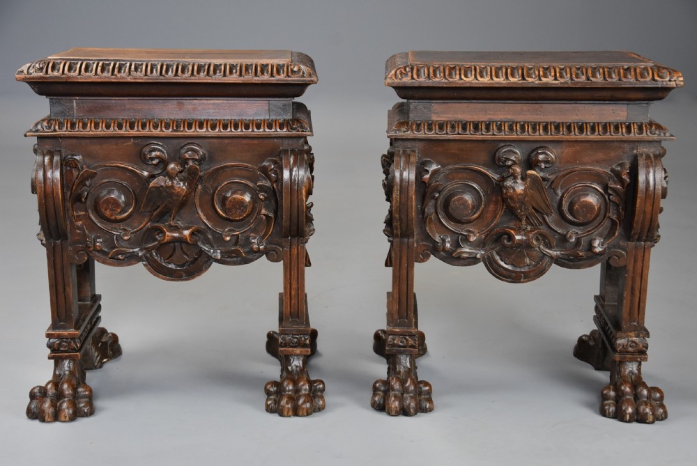 A pair of carved warm brown walnut stools with gadrooned tops, central bird reliefs, scrollwork aprons, and paw feet. View IV