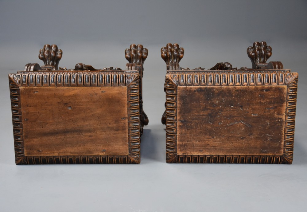 A pair of carved warm brown walnut stools with gadrooned tops, central bird reliefs, scrollwork aprons, and paw feet. View XIII