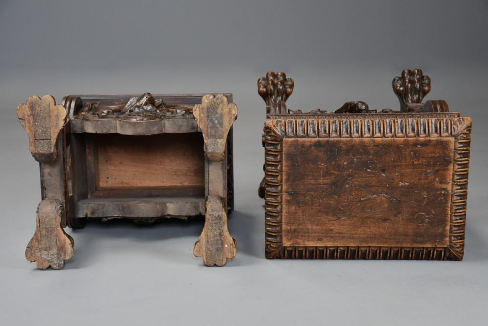 A pair of carved warm brown walnut stools with gadrooned tops, central bird reliefs, scrollwork aprons, and paw feet. View XIV