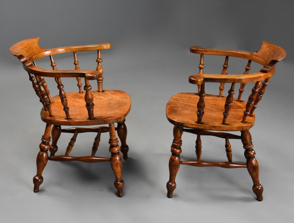A pair of 19th-century birch smokers bow Windsor armchairs featuring steam-bent armrails, turned spindles, saddle seats, and turned legs with stretchers. View VII