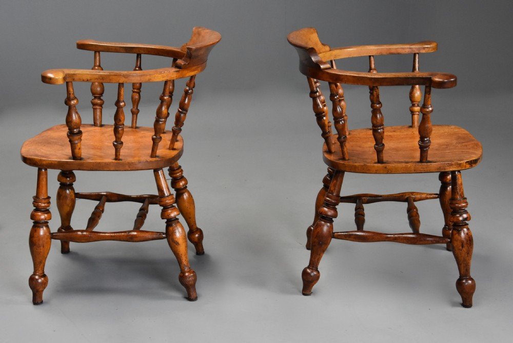 A pair of 19th-century birch smokers bow Windsor armchairs featuring steam-bent armrails, turned spindles, saddle seats, and turned legs with stretchers. View VIII