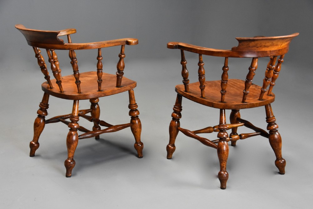 A pair of 19th-century birch smokers bow Windsor armchairs featuring steam-bent armrails, turned spindles, saddle seats, and turned legs with stretchers. View IX