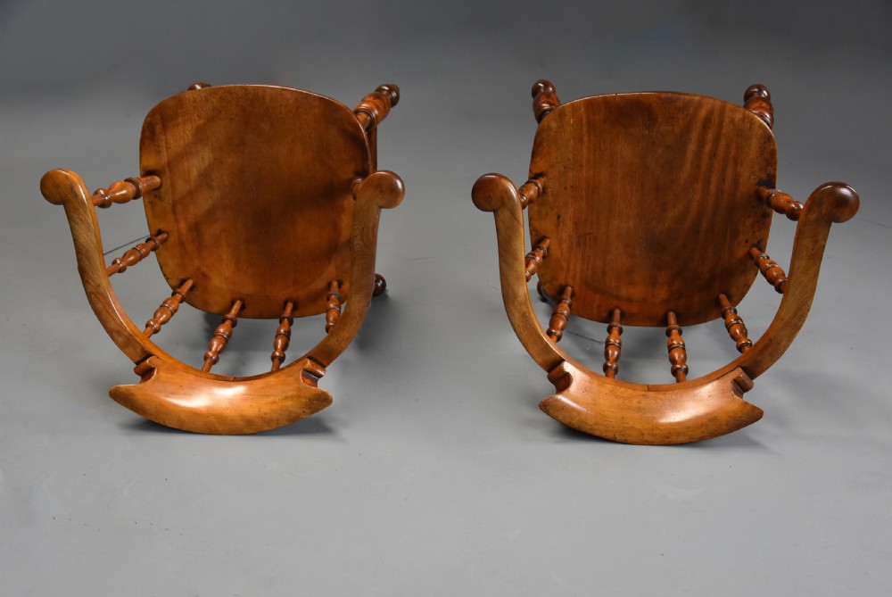 A pair of 19th-century birch smokers bow Windsor armchairs featuring steam-bent armrails, turned spindles, saddle seats, and turned legs with stretchers. View XI