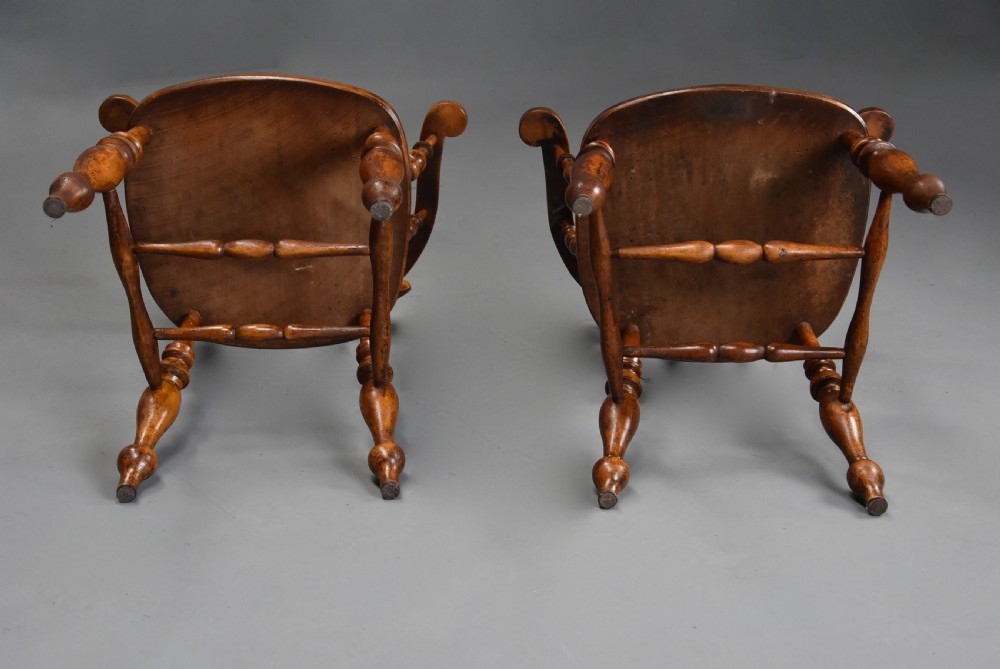 A pair of 19th-century birch smokers bow Windsor armchairs featuring steam-bent armrails, turned spindles, saddle seats, and turned legs with stretchers. View XII