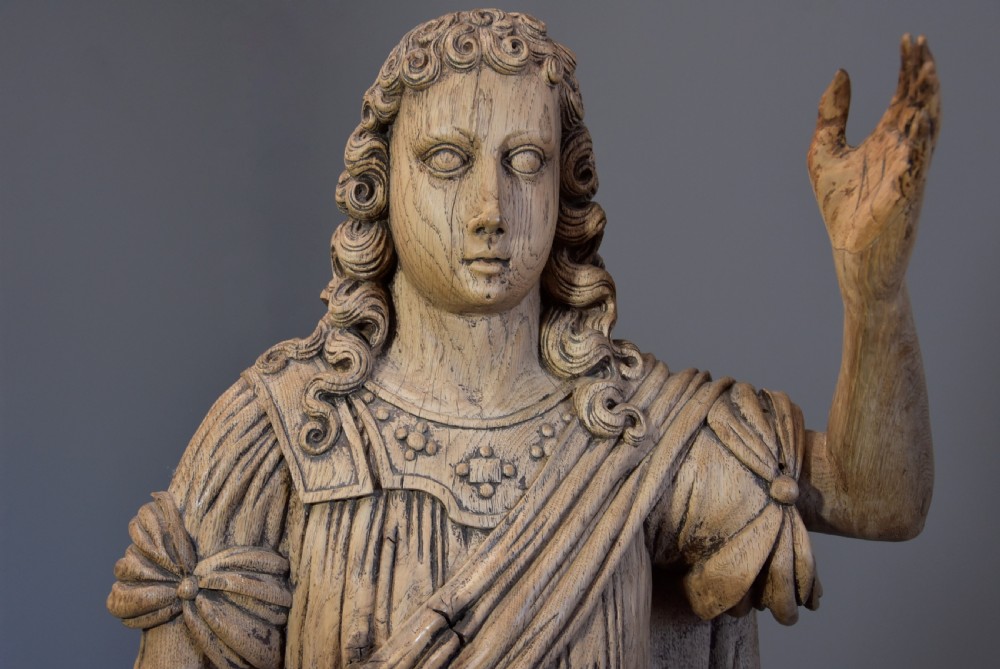 An 18th-century Continental carved oak figure depicting classical drapery standing on a turned pedestal. View V