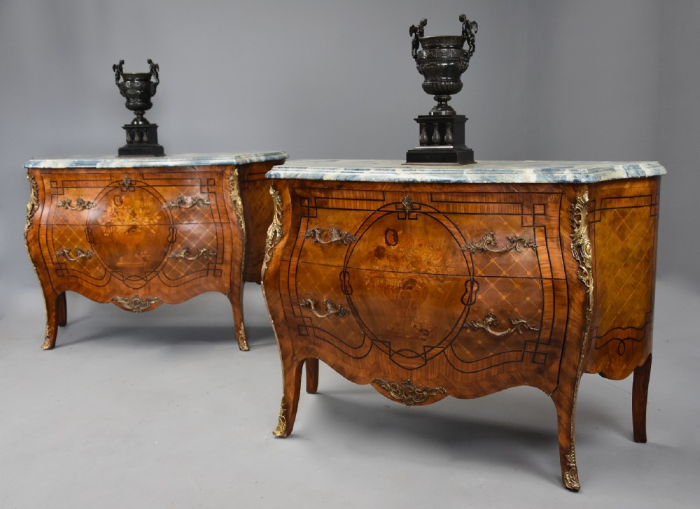 A pair of early twentieth-century French Kingwood bombe commodes featuring floral marquetry panels, serpentine blue marble tops, and detailed gilt-bronze mounts. View III