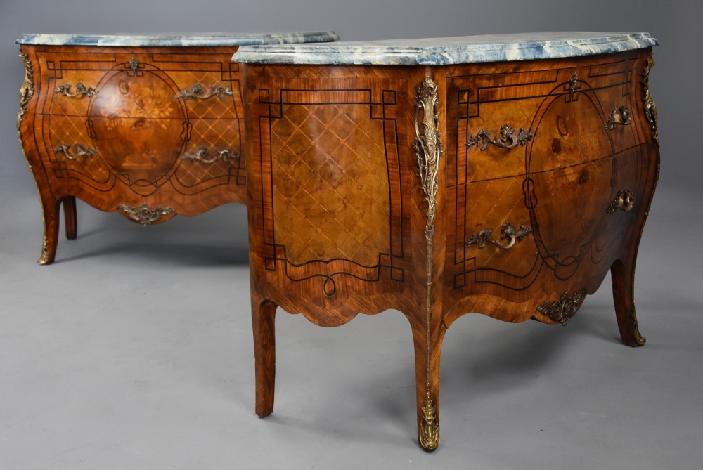 A pair of early twentieth-century French Kingwood bombe commodes featuring floral marquetry panels, serpentine blue marble tops, and detailed gilt-bronze mounts. View IV