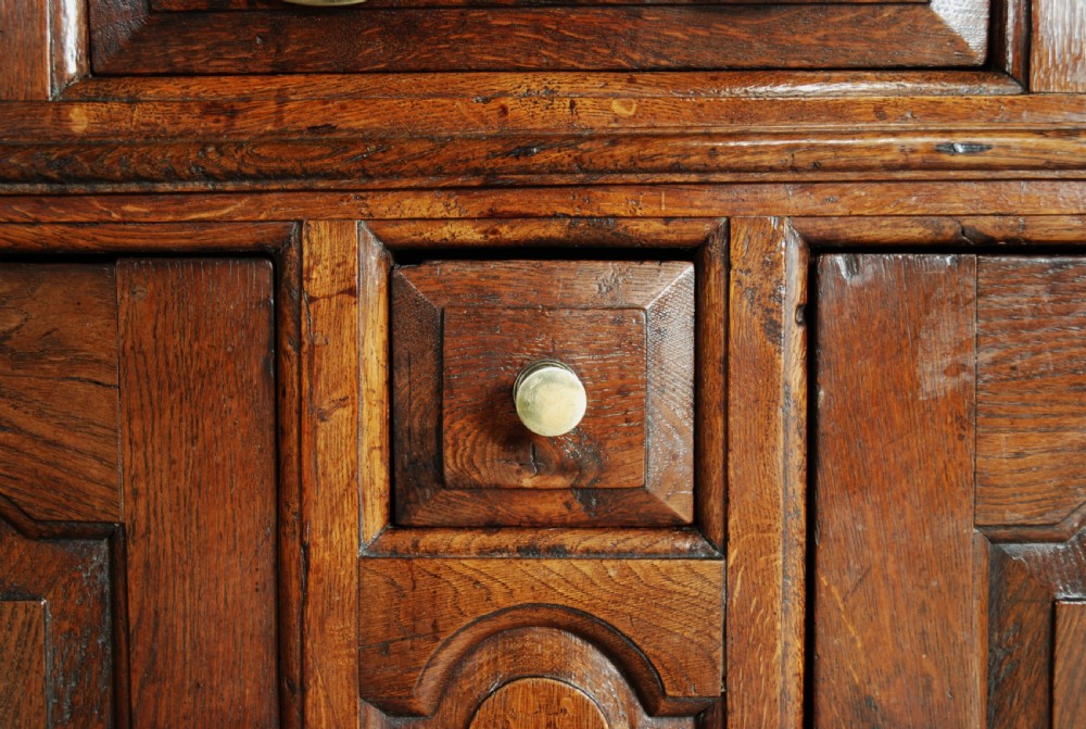A mid-18th-century three-tier Welsh oak cwpwrdd tridarn featuring an open top canopy, carved panel dated 1761, turned pillars, and lower cupboards. View X