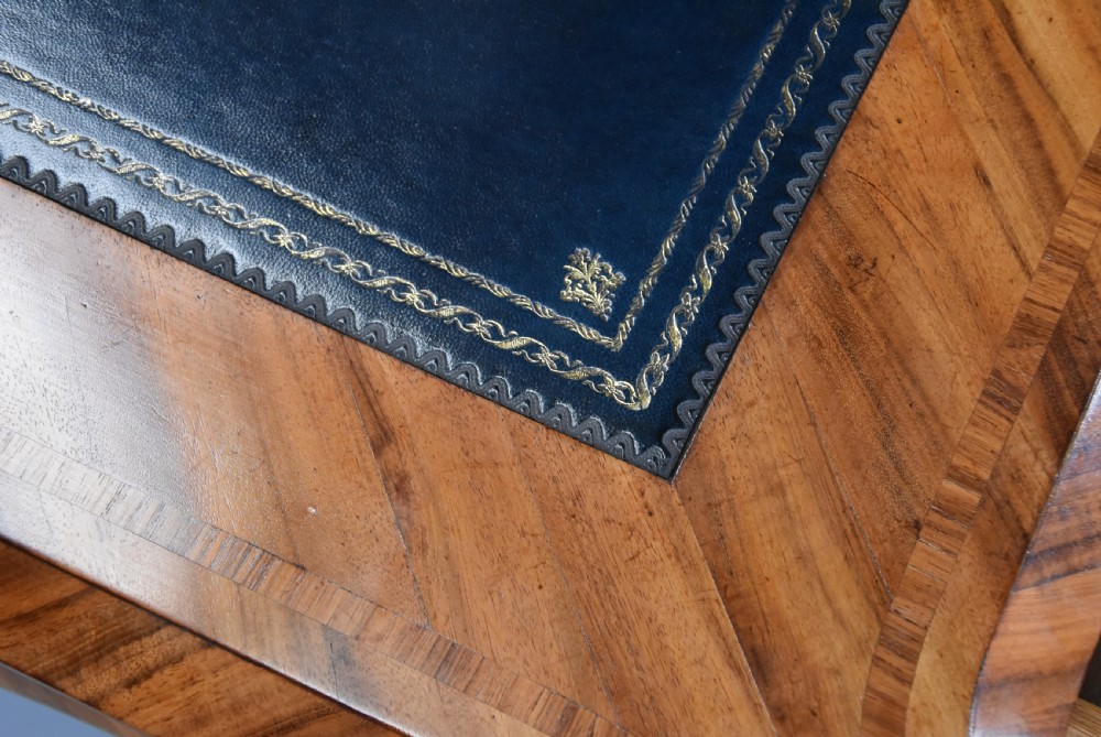 A mid-19th-century French-style writing desk made from figured Goncalo Alves timber, featuring three drawers, gilt bronze Rococo mounts, cabriole legs, and a black leather inset top. View X