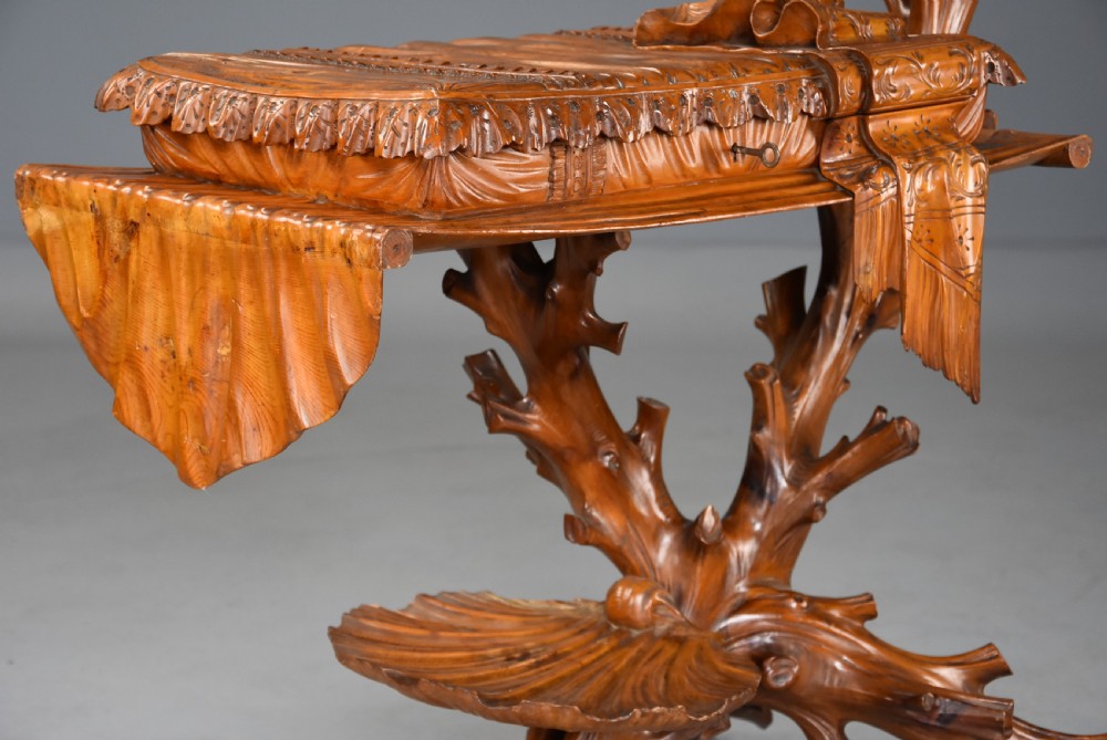 A late nineteenth-century Italian carved pine grotto work table featuring tree-branch legs, a shell shelf, and a top detailed as a cushion with draped cloth. View VII