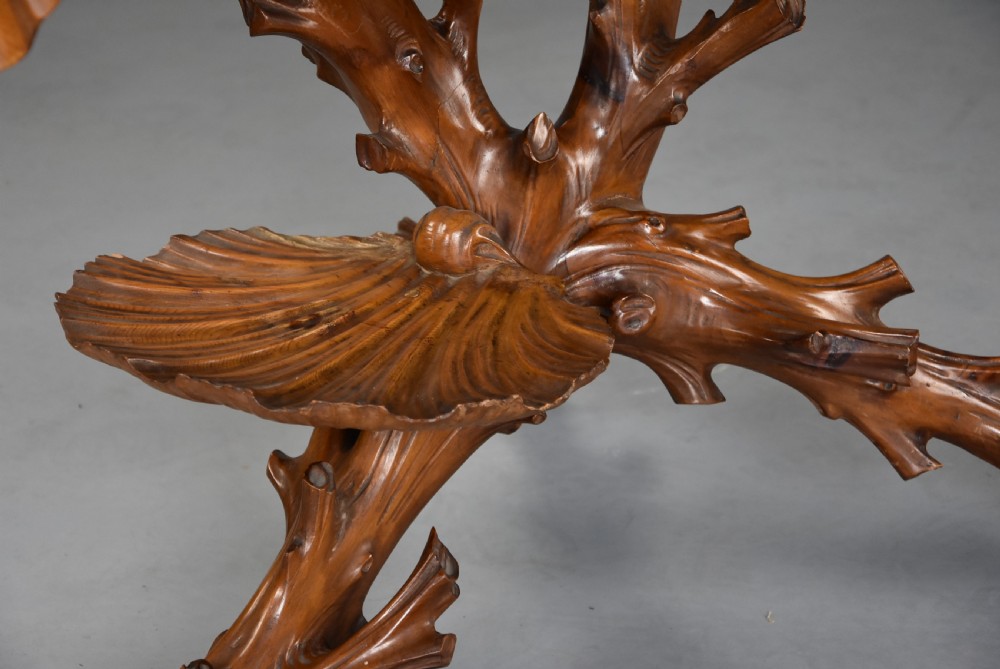A late nineteenth-century Italian carved pine grotto work table featuring tree-branch legs, a shell shelf, and a top detailed as a cushion with draped cloth. View X