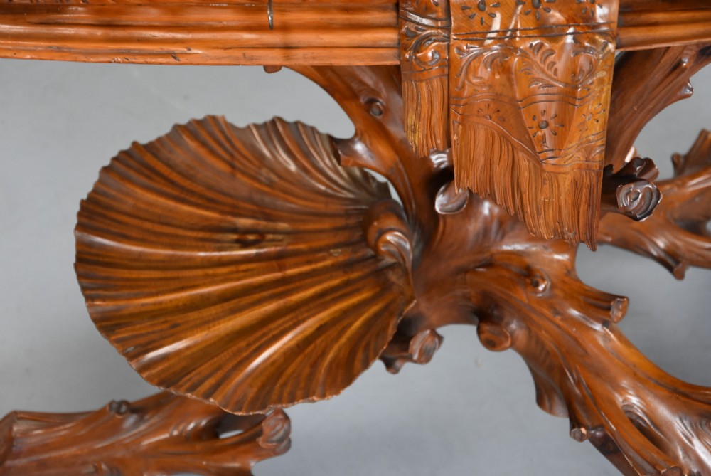A late nineteenth-century Italian carved pine grotto work table featuring tree-branch legs, a shell shelf, and a top detailed as a cushion with draped cloth. View XI