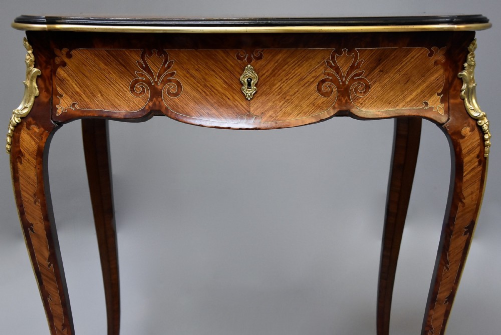A 19th-century French kingwood occasional table featuring cabriole legs, marquetry inlay, serpentine top, and gilt-bronze ormolu mounts. View V