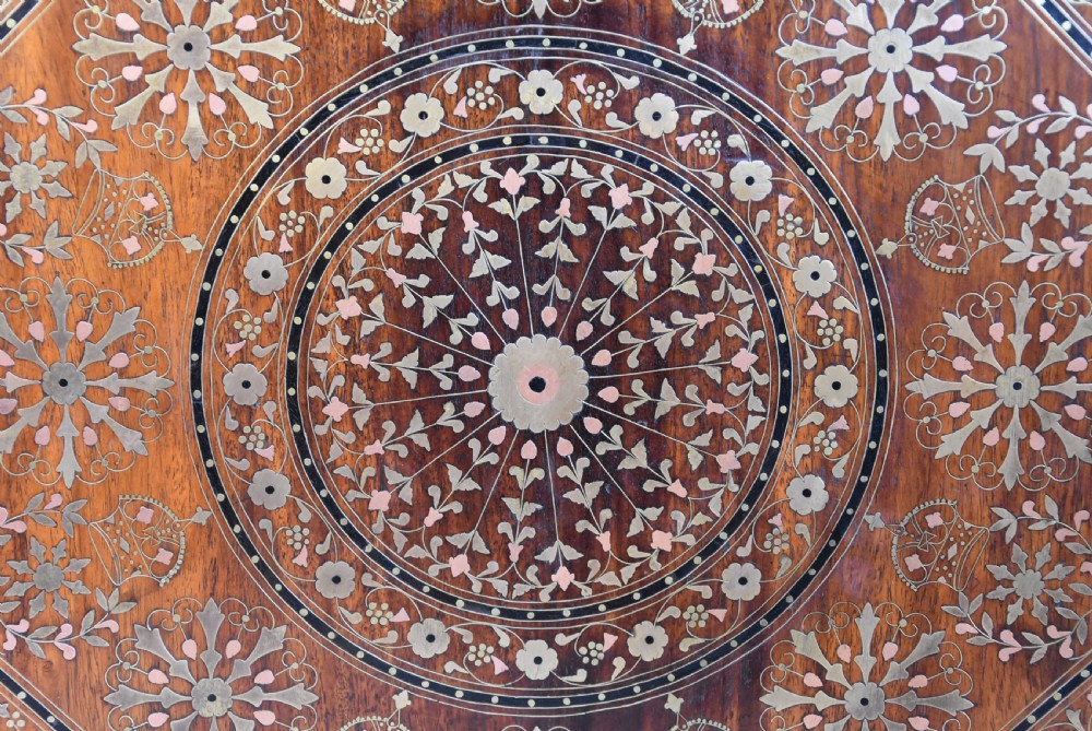 A late nineteenth-century Anglo-Indian octagonal table crafted from dark wood with intricate floral bone inlay on top and carved fretwork panels along the base. View VII