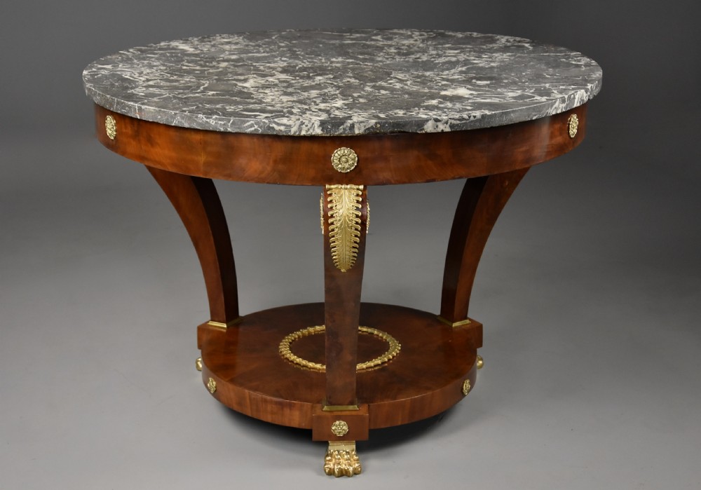 A late 19th-century French Empire style circular gueridon table featuring a grey marble top, mahogany frame with gilded bronze mounts, and curved legs with paw feet. View III