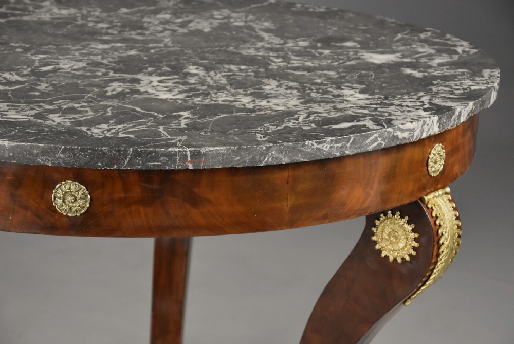 A late 19th-century French Empire style circular gueridon table featuring a grey marble top, mahogany frame with gilded bronze mounts, and curved legs with paw feet. View VII