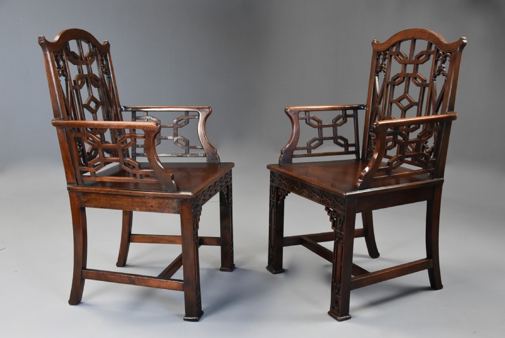A pair of 18th-century mahogany open armchairs featuring intricate geometric Chinese lattice backrests, fretted arm supports, and carved straight legs. View V