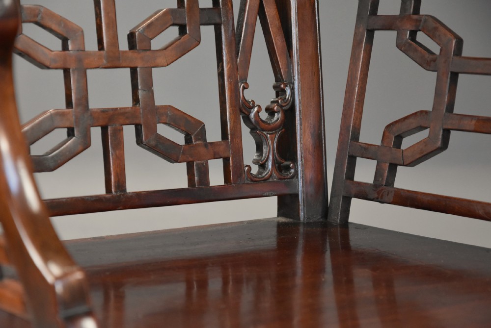 A pair of 18th-century mahogany open armchairs featuring intricate geometric Chinese lattice backrests, fretted arm supports, and carved straight legs. View XII