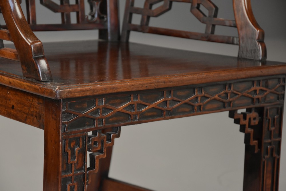 A pair of 18th-century mahogany open armchairs featuring intricate geometric Chinese lattice backrests, fretted arm supports, and carved straight legs. View XIII