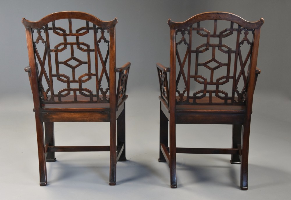 A pair of 18th-century mahogany open armchairs featuring intricate geometric Chinese lattice backrests, fretted arm supports, and carved straight legs. View XV