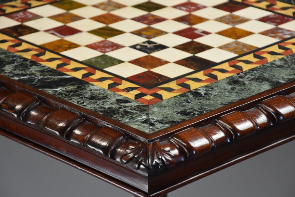 A mid-19th century rosewood games table featuring a square specimen marble inlaid chessboard top resting on a carved pedestal stem and scroll feet. View III