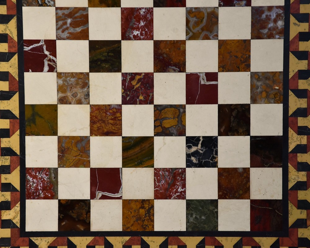 A mid-19th century rosewood games table featuring a square specimen marble inlaid chessboard top resting on a carved pedestal stem and scroll feet. View V