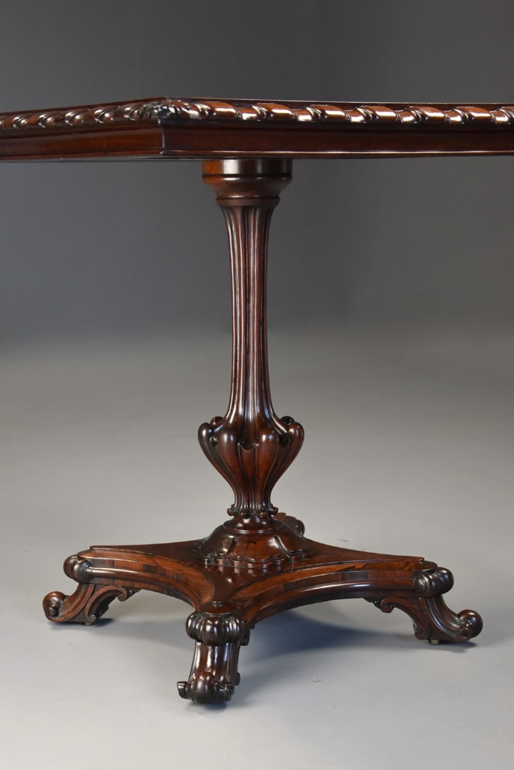 A mid-19th century rosewood games table featuring a square specimen marble inlaid chessboard top resting on a carved pedestal stem and scroll feet. View VI