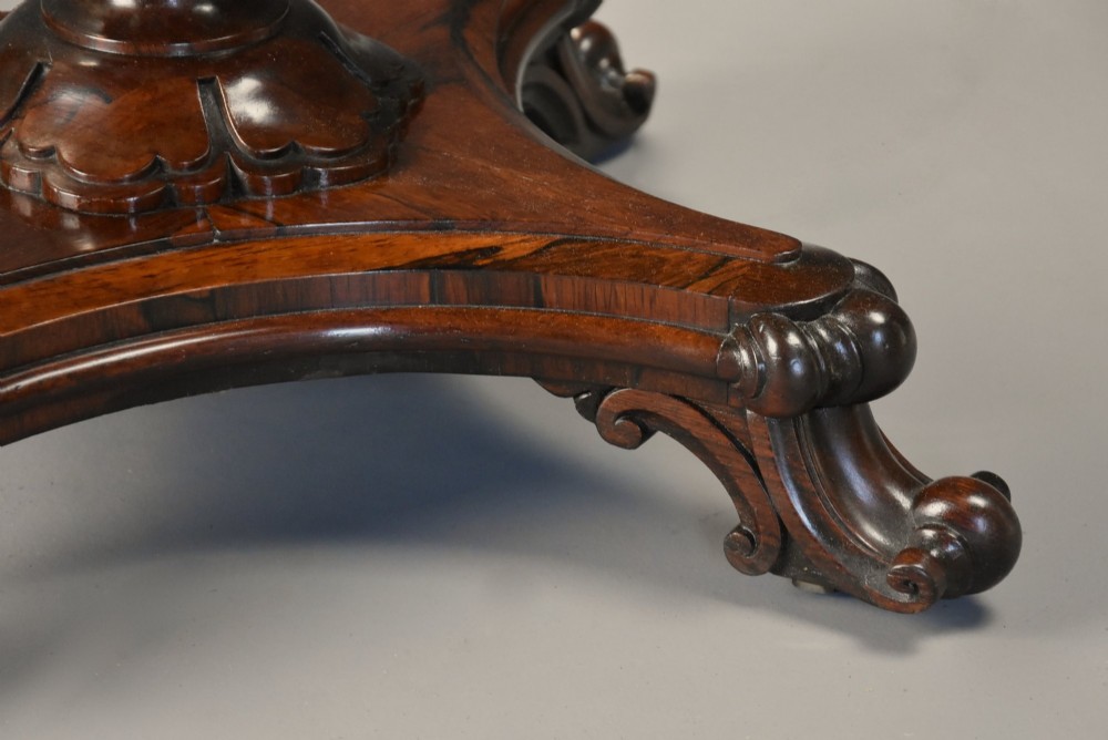 A mid-19th century rosewood games table featuring a square specimen marble inlaid chessboard top resting on a carved pedestal stem and scroll feet. View IX