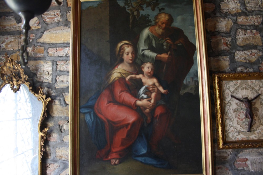 An 18th-century oil painting on canvas depicting the Holy Family set in a narrow gilded wooden frame. View X
