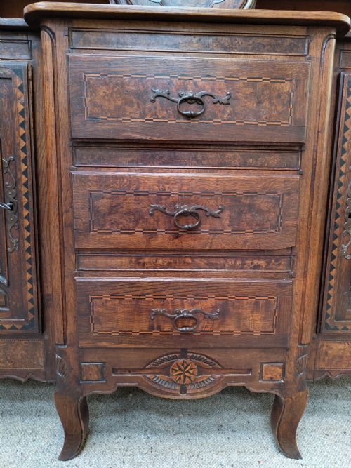 fig 2. A carved oak French provincial clock dresser featuring an integrated central longcase clock, open shelving, and a lower sideboard with drawers and cupboards.