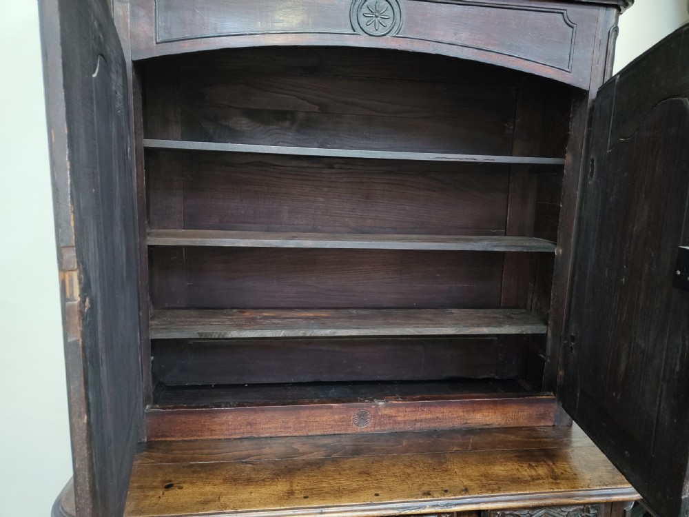 An antique dark oak French Provincial dresser featuring intricate relief carvings of figurative village scenes on four cupboard doors and three drawers. View XI