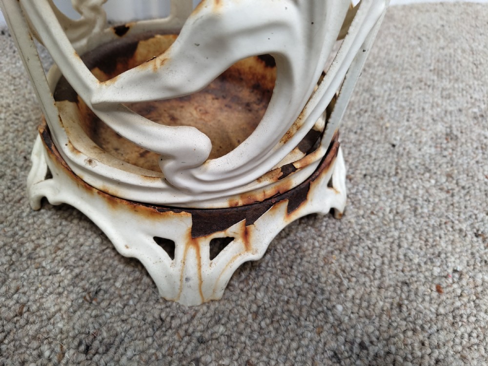 An antique white-painted cast iron cylindrical umbrella stand featuring ornate openwork foliate scrolls and a circular drip pan base. View IV