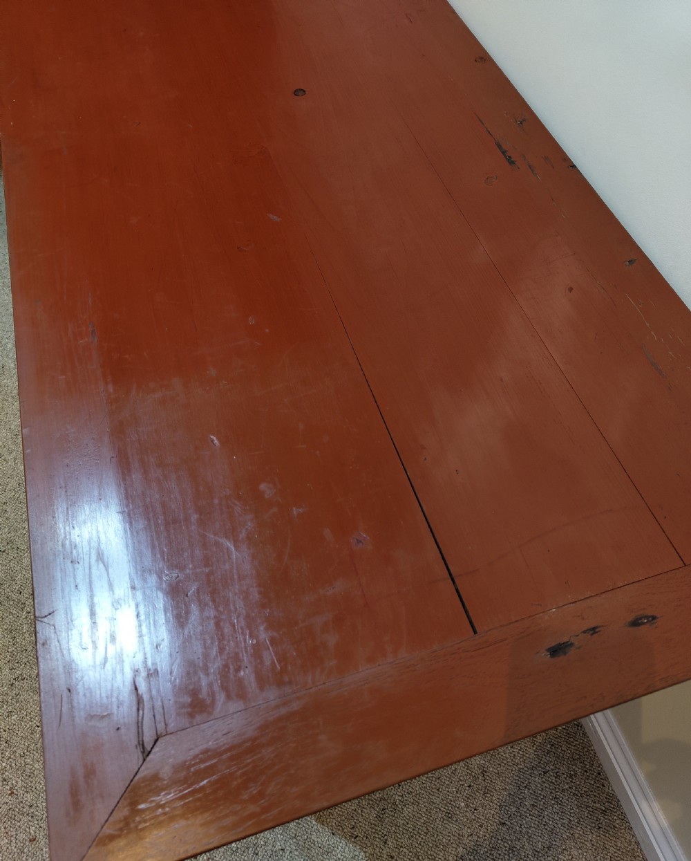 An antique Chinese red lacquer console table featuring two carved drawers with dark metal handles and extended top edges. View X