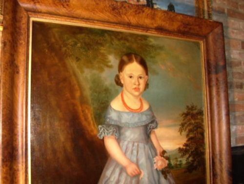 fig 1. An antique oil portrait on canvas depicting a young girl in a blue dress holding a rose, displayed within a wide flame wood frame.