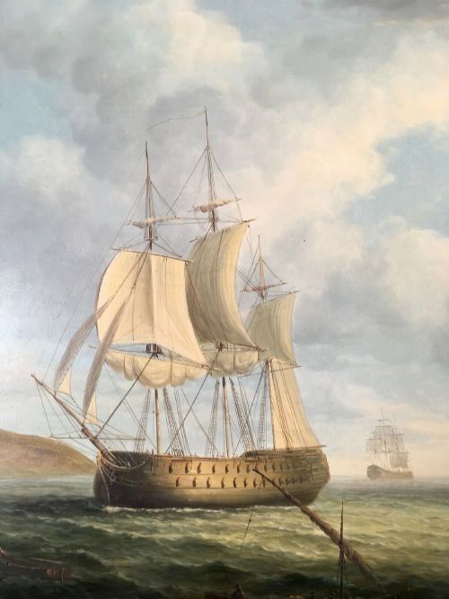 fig 4. A 19th-century style marine oil painting on panel depicting a large sailing warship anchored near a stone coastal fortification under a cloudy sky, presented in a heavily moulded gold gilt frame.