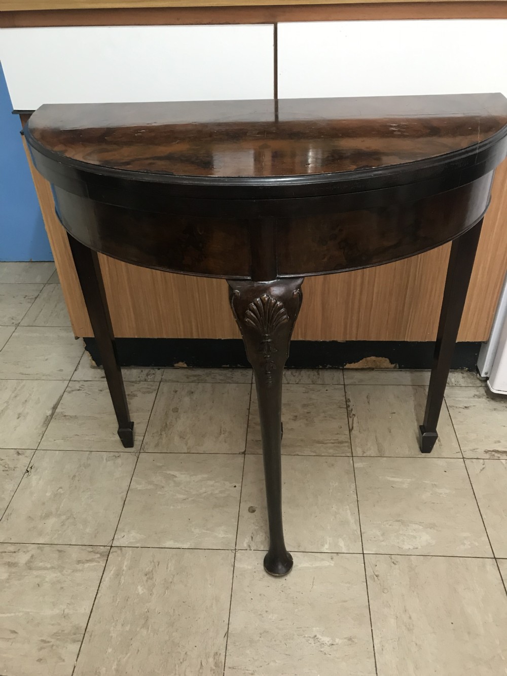 A 19th-century walnut veneer demilune folding card table with green baize playing surface and cabriole legs. View X